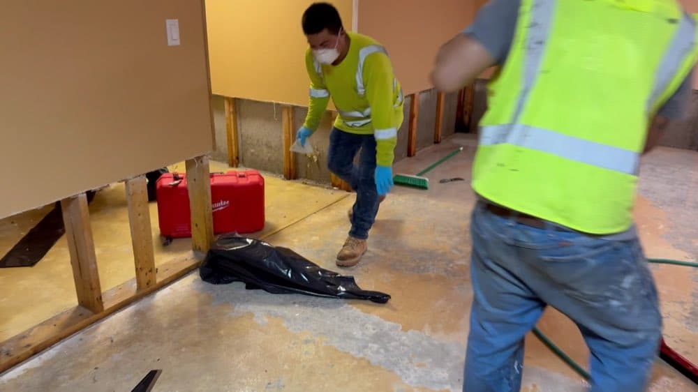 Crew making flood cuts in water-damaged drywall